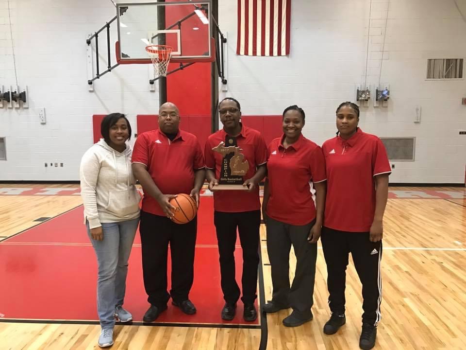 Watkins and his coaching staff with a girls basketball district championship trophy